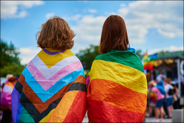 Dos personas con banderas del orgullo